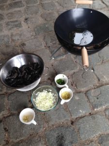 Mosselen met gember en whisky zet alle ingrediënten klaar met de wok in de kolen