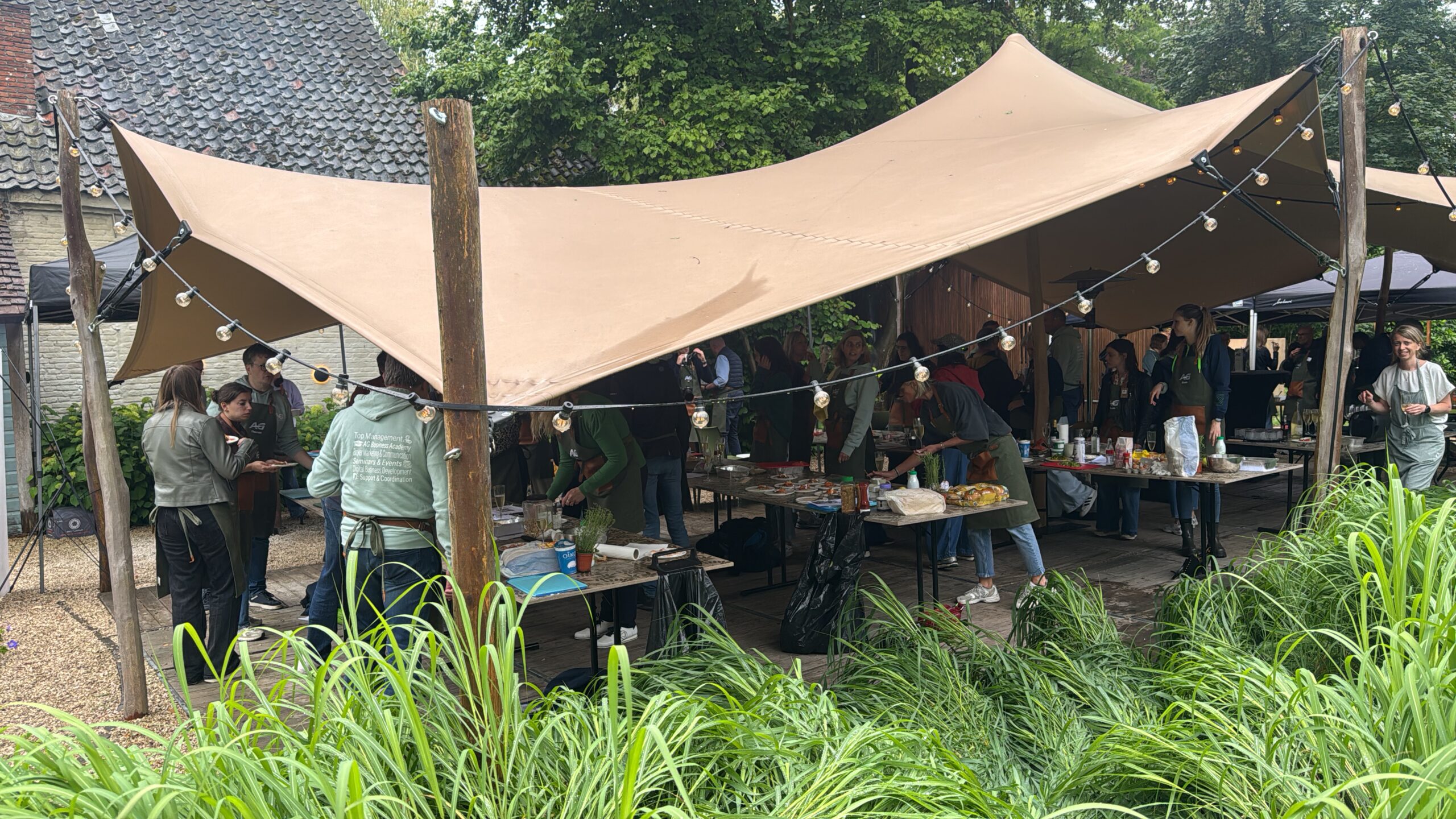 mensen die bezig zijn met de bbq workshop onder een tent